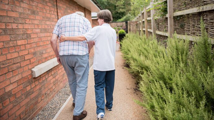 older man being assisted with walking