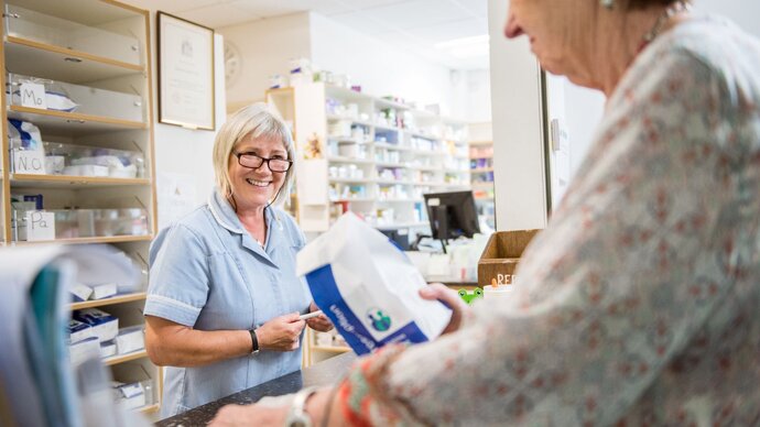 pharmacist giving patient medication bag